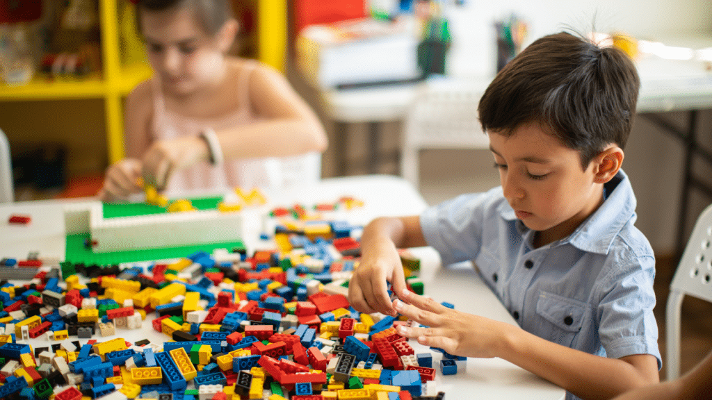 Children in childcare focusing on building communication skills through Lego play.